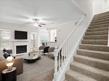 A living room with a staircase and a ceiling fan